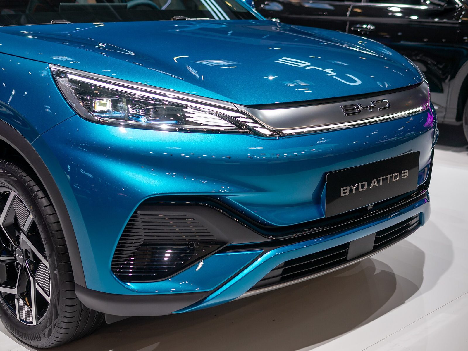 Frente de un BYD Atto 3 azul en exhibición, con el logo BYD sobre la parrilla; en Uruguay este modelo se vende como Yuan Plus