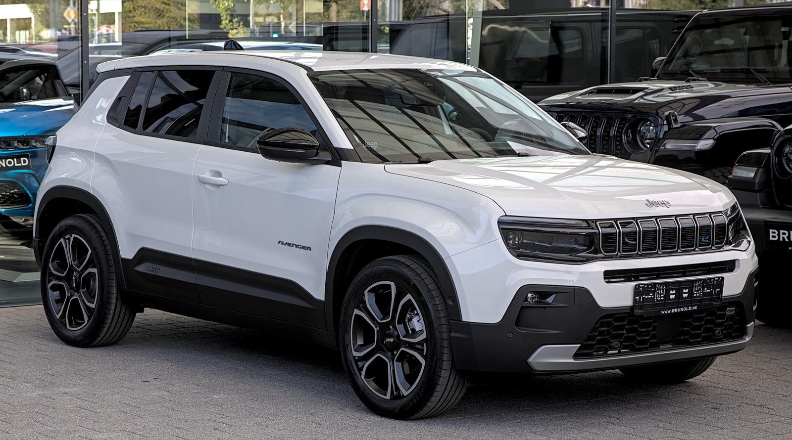 Jeep Avenger eléctrico blanco, vista frontal tres cuartos, en la explanada de un concesionario europeo