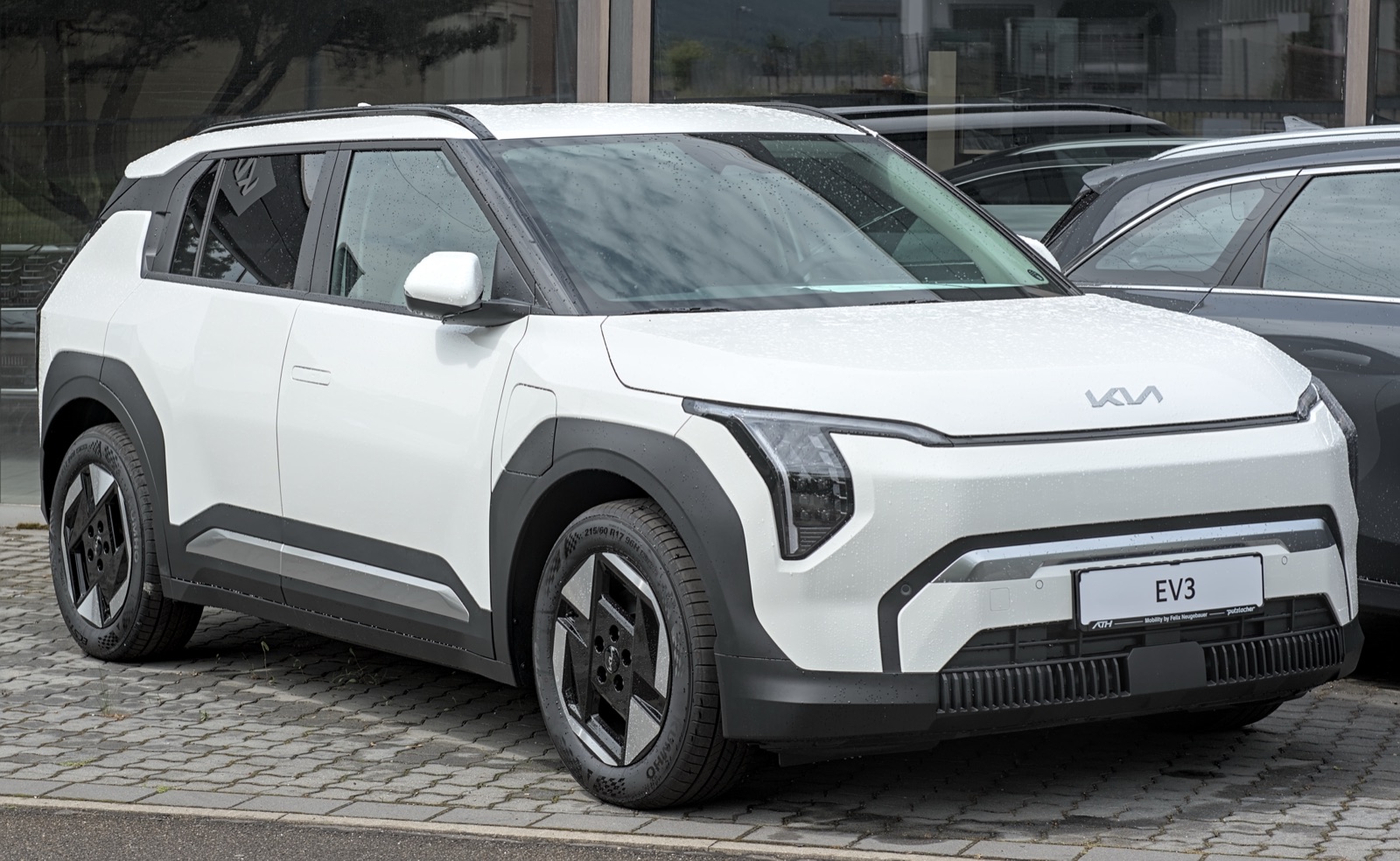 Kia EV3 blanco visto de frente y de costado, estacionado en la calle