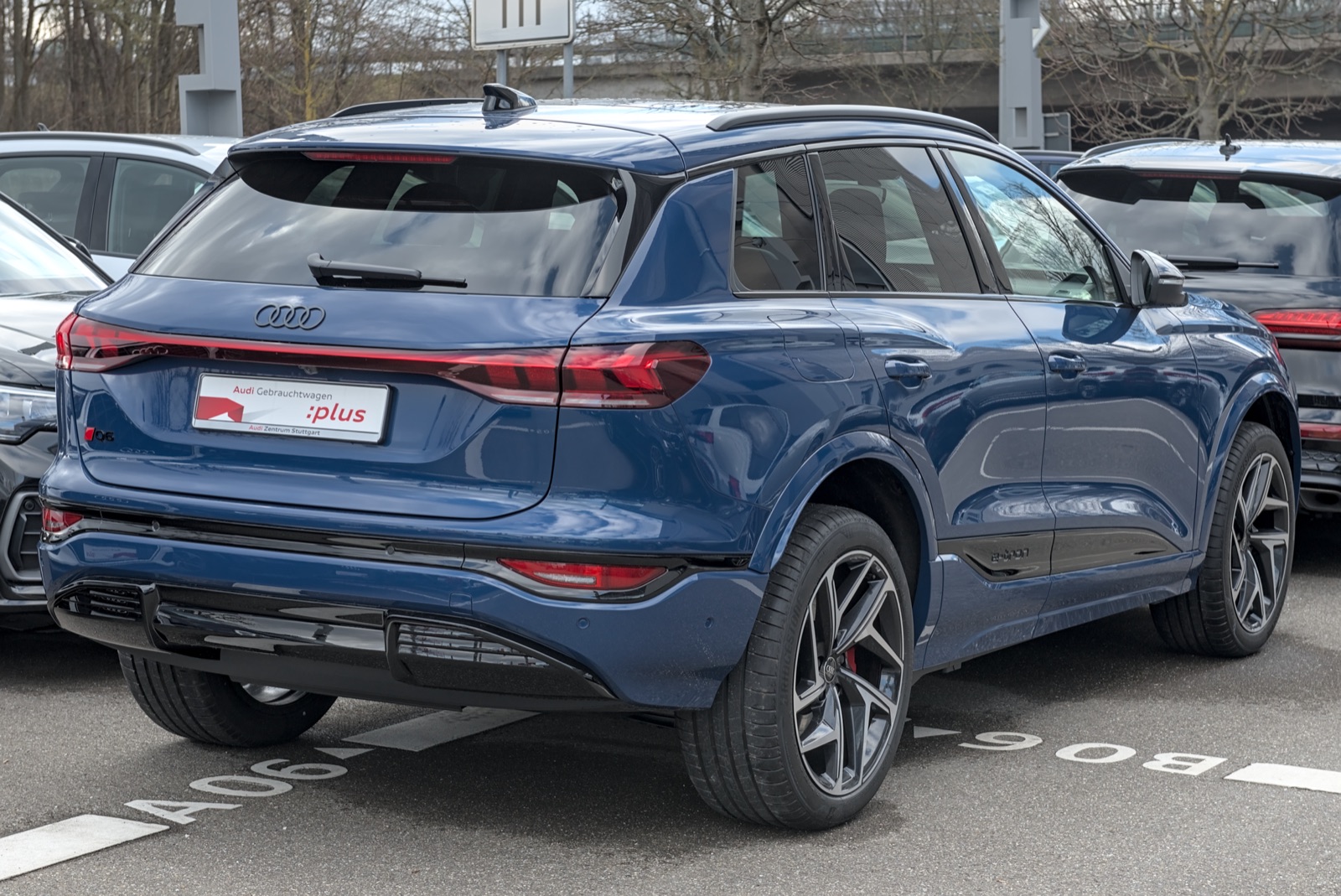 Audi Q6 e-tron azul, vista trasera tres cuartos, en una playa de concesionario